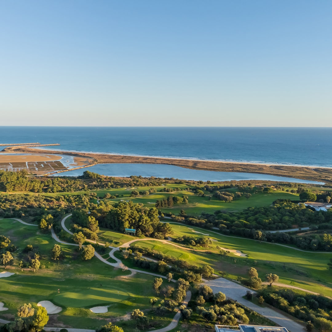 Aerial view of Palmares Golf’s parkland and lakeside fairways with Atlantic Ocean in background, Lagos, Algarve.