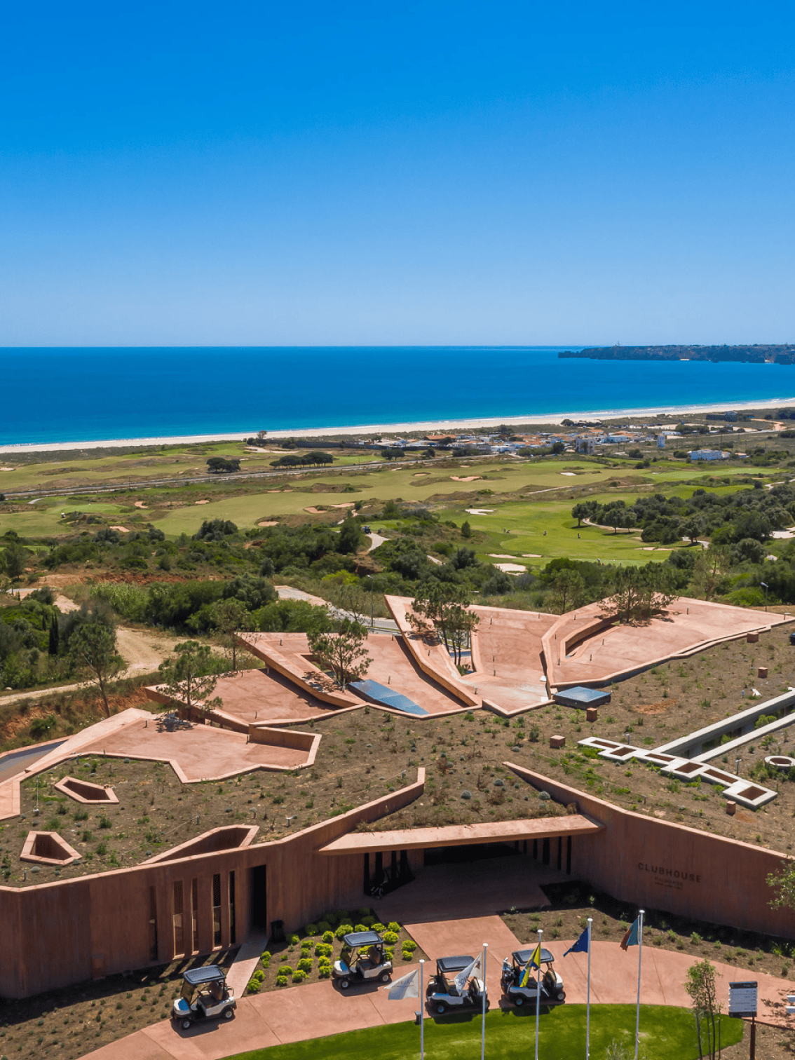 Vista do clubhouse de arquitetura contemporânea com o mar ao fundo em Palmares, Lagos.