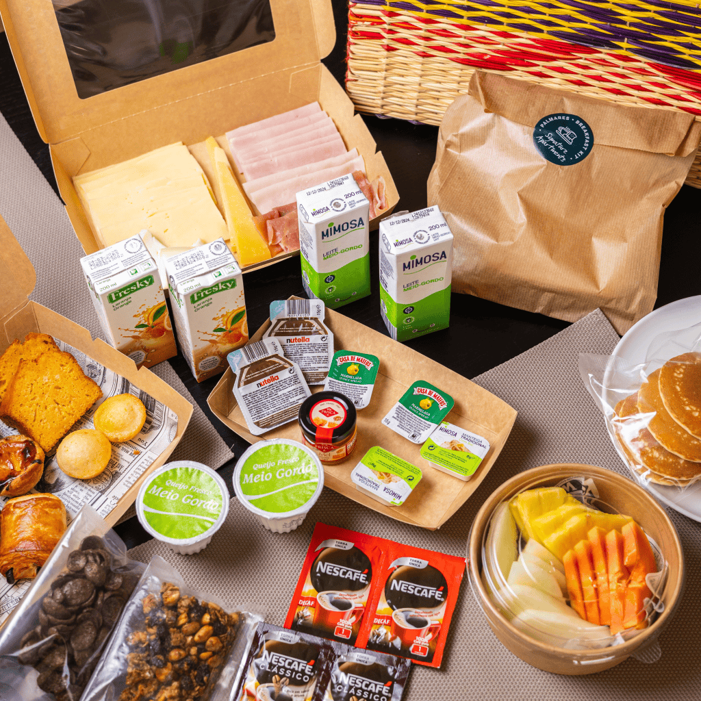 Vista geral do Palmares Breakfast Kit com seleção de produtos, incluindo leite, sumos, pastelaria e fruta.