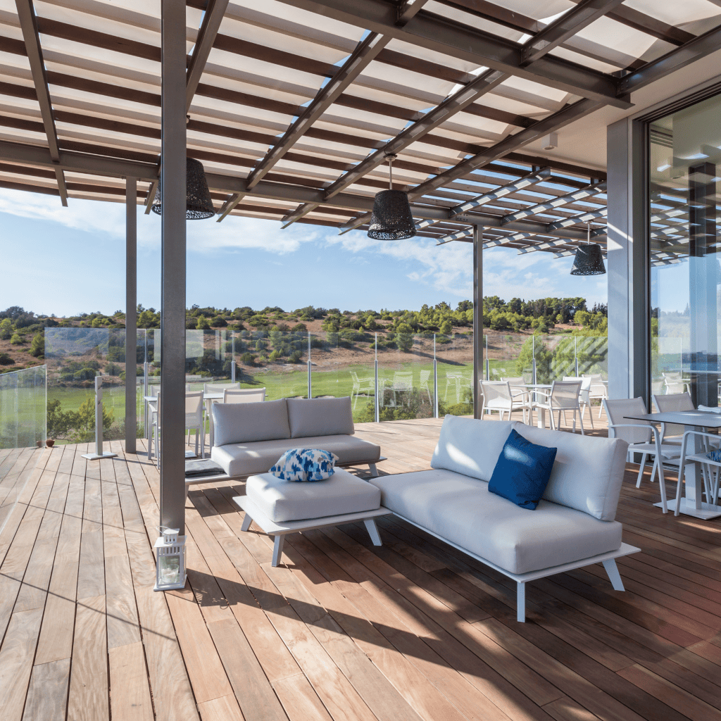 Esplanada privada de uma suite no Palmares Living, com sofás confortáveis e vista relaxante para o campo de golfe.