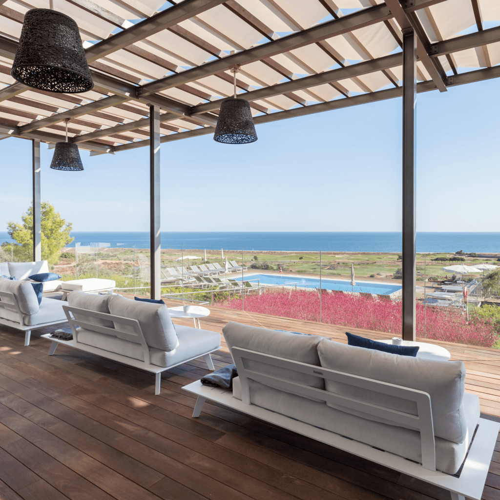 Terraço lounge com sofás brancos e vista deslumbrante para o mar no Palmares Beach House Hotel.